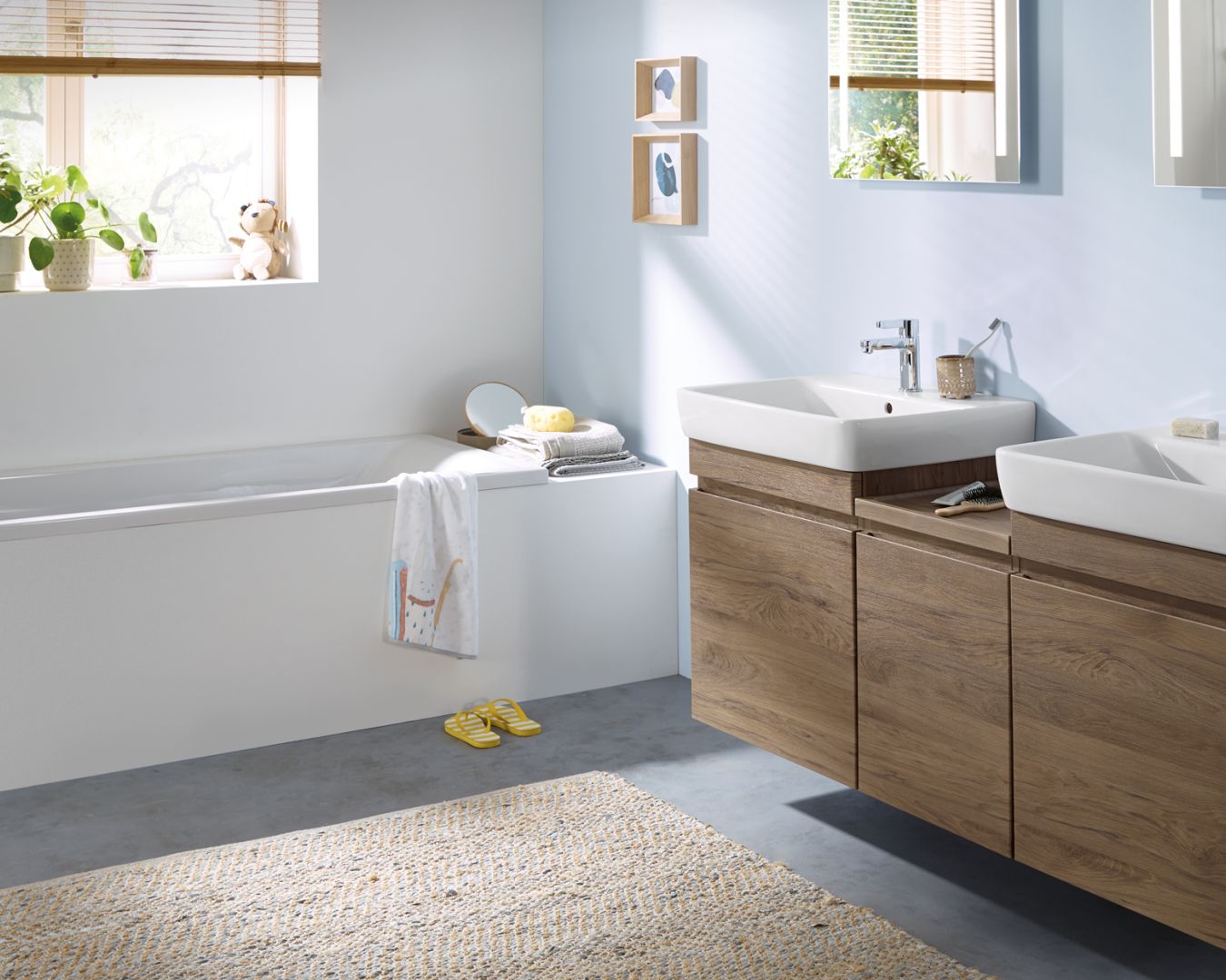 geberit Helles Familienbad mit Doppelwaschtisch, Badewanne und Holzdekor.