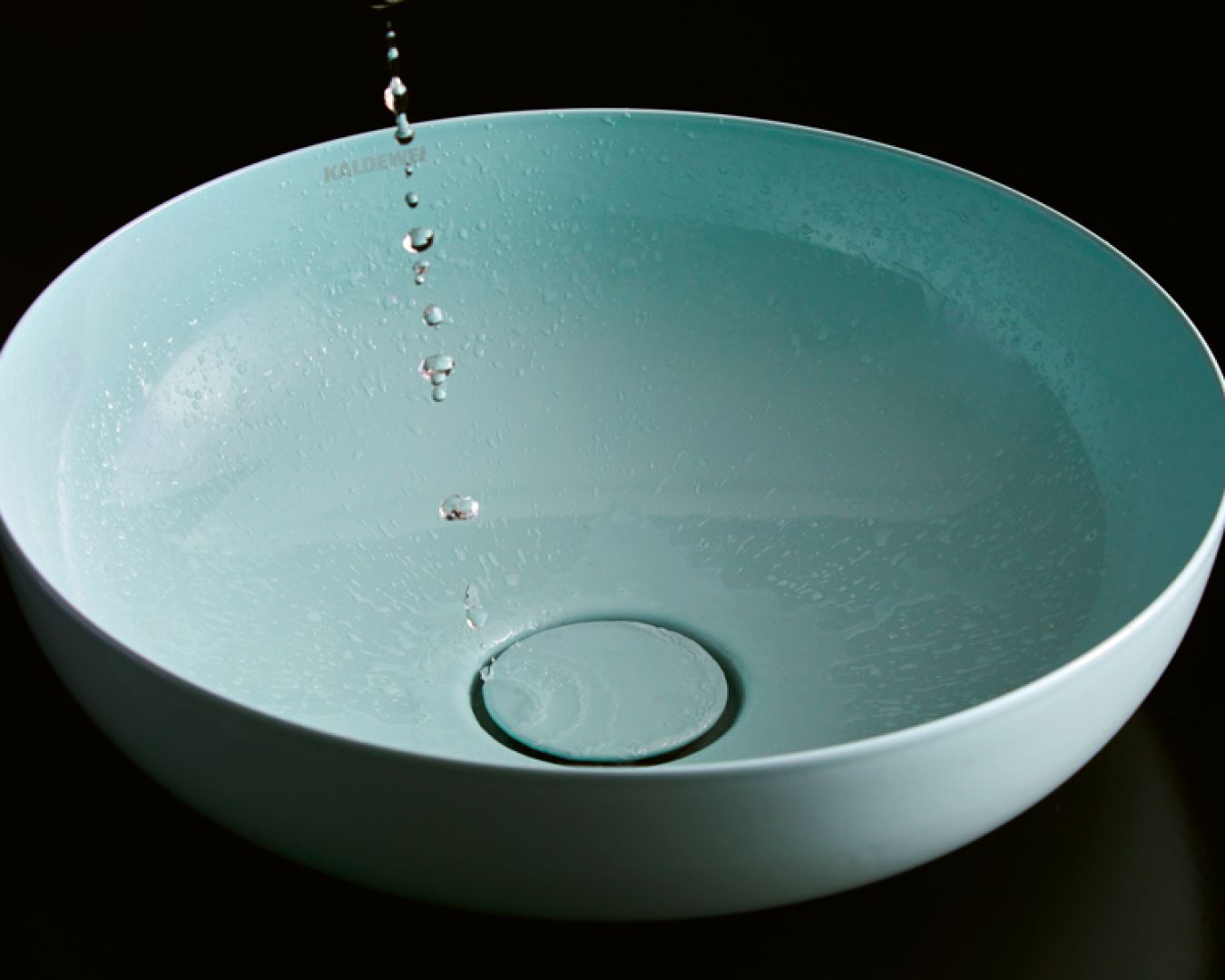 Türkises Waschbecken mit Wassertropfen