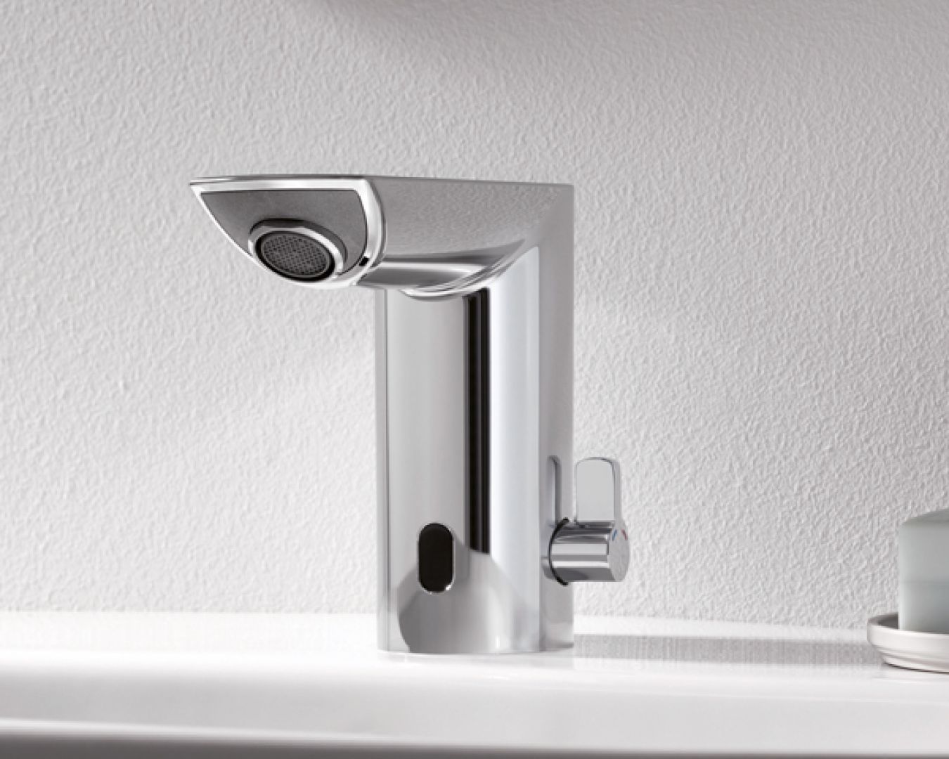 Moderne Armatur mit eckigem Design an grauer Wand über weißem Waschbecken