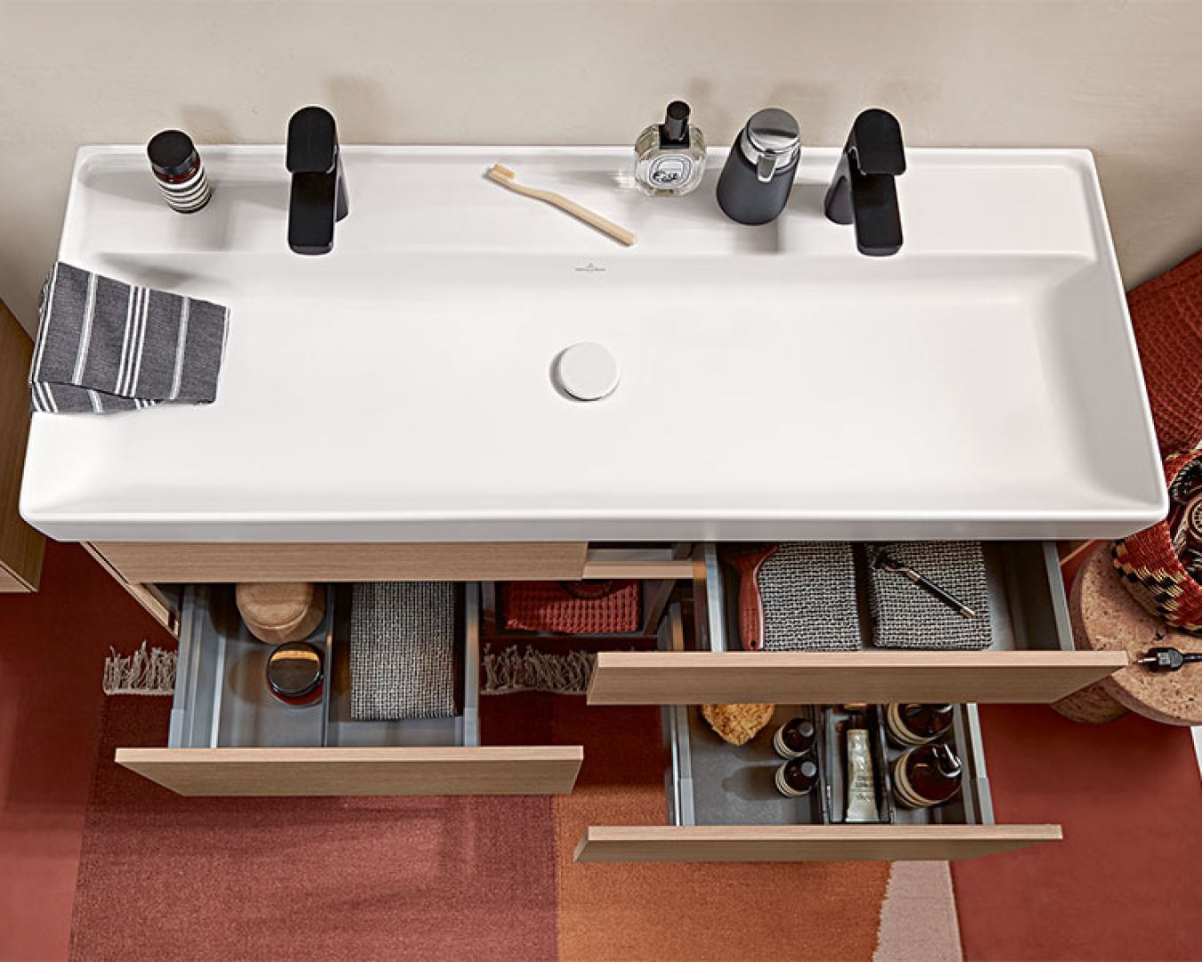 Modernes Waschbecken mit Stauraum und geöffneter Schublade von oben.