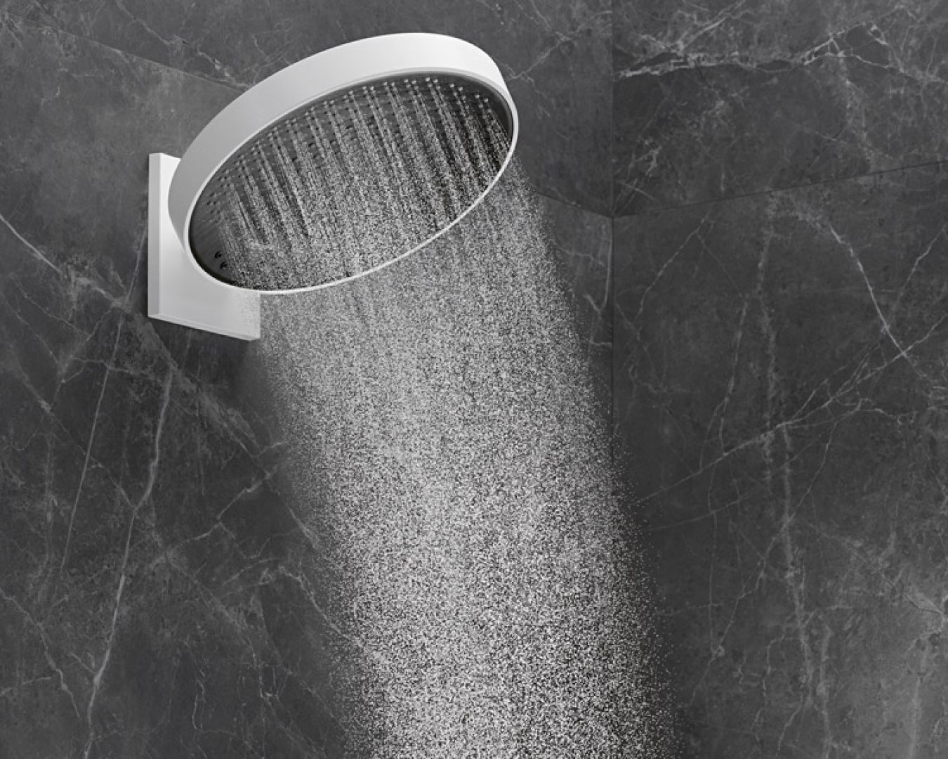 Große runde Regendusche mit feinem Wasserstrahl vor dunkler Steinwand