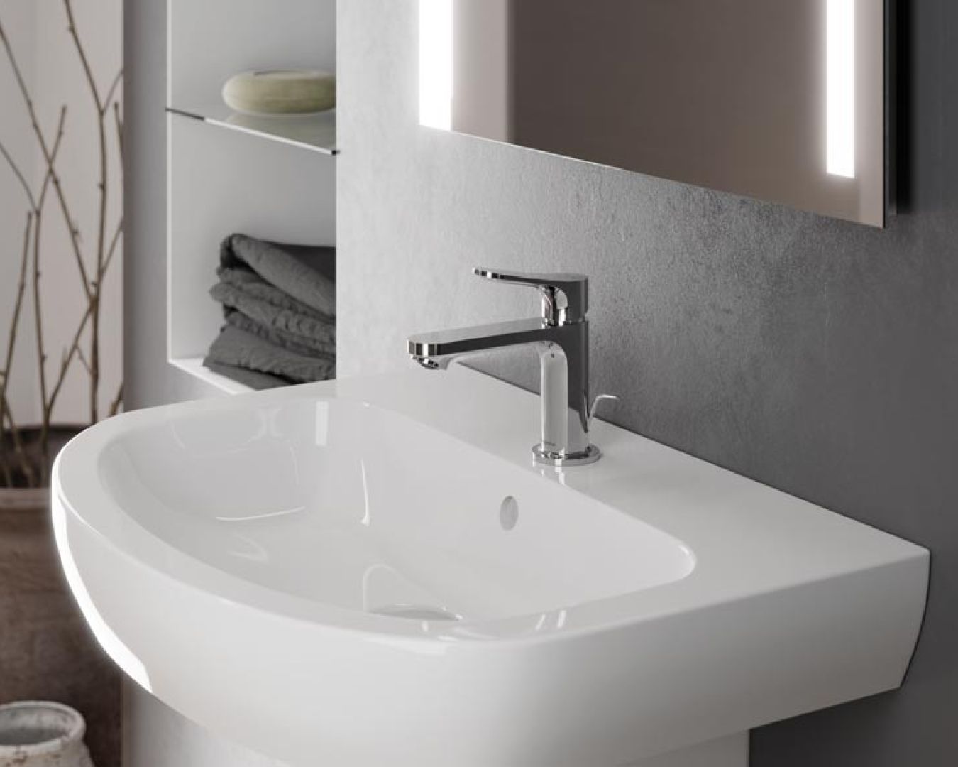 Modernes Waschbecken mit breitem Rand und glänzender Armatur an grauer Wand.