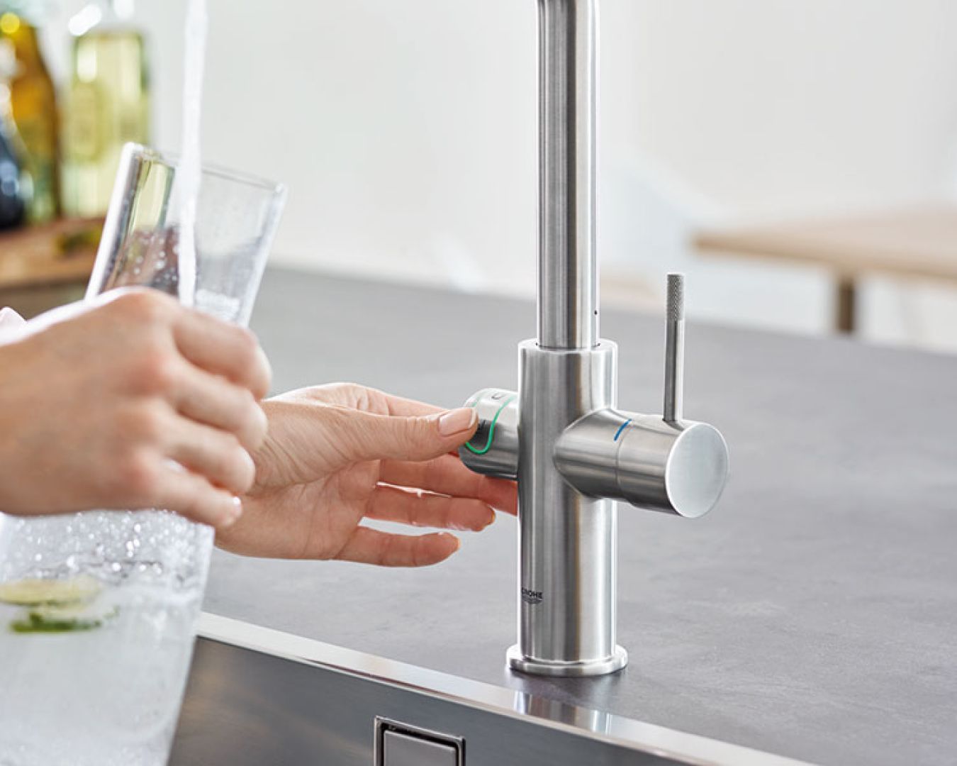 Moderne Küchenarmatur aus Edelstahl mit Glas und fließendem Wasser
