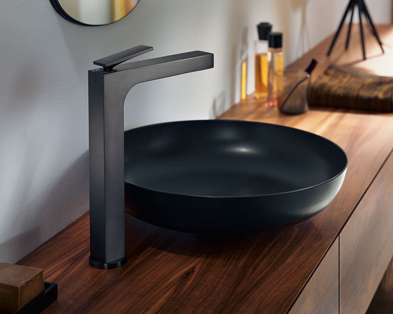 Schwarzer Design-Waschtisch mit matter Armatur auf Holzkonsole.