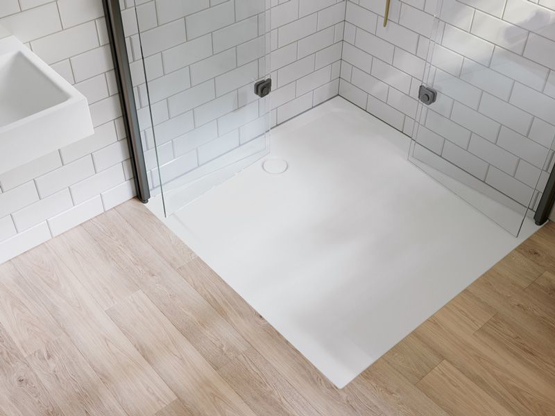 kaldewei Bodengleiche Dusche mit Glaswänden, Holzoptik-Boden und weißen Fliesen.