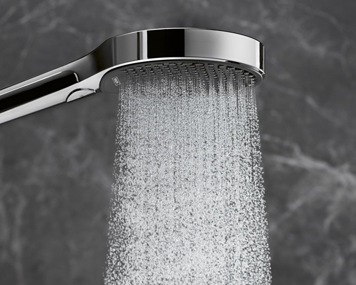 Handbrause mit gleichmäßigem Wasserstrahl vor grauer Marmorwand
