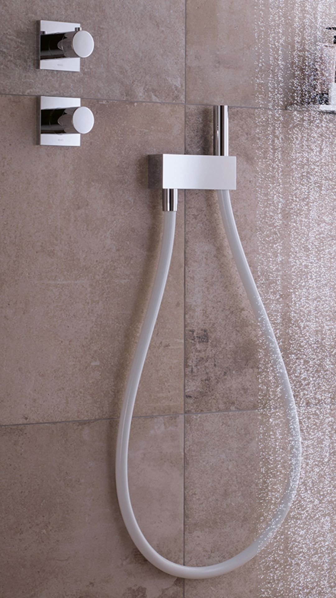 Moderne Duscharmatur mit glänzender Oberfläche und feinen Wasserperlen.