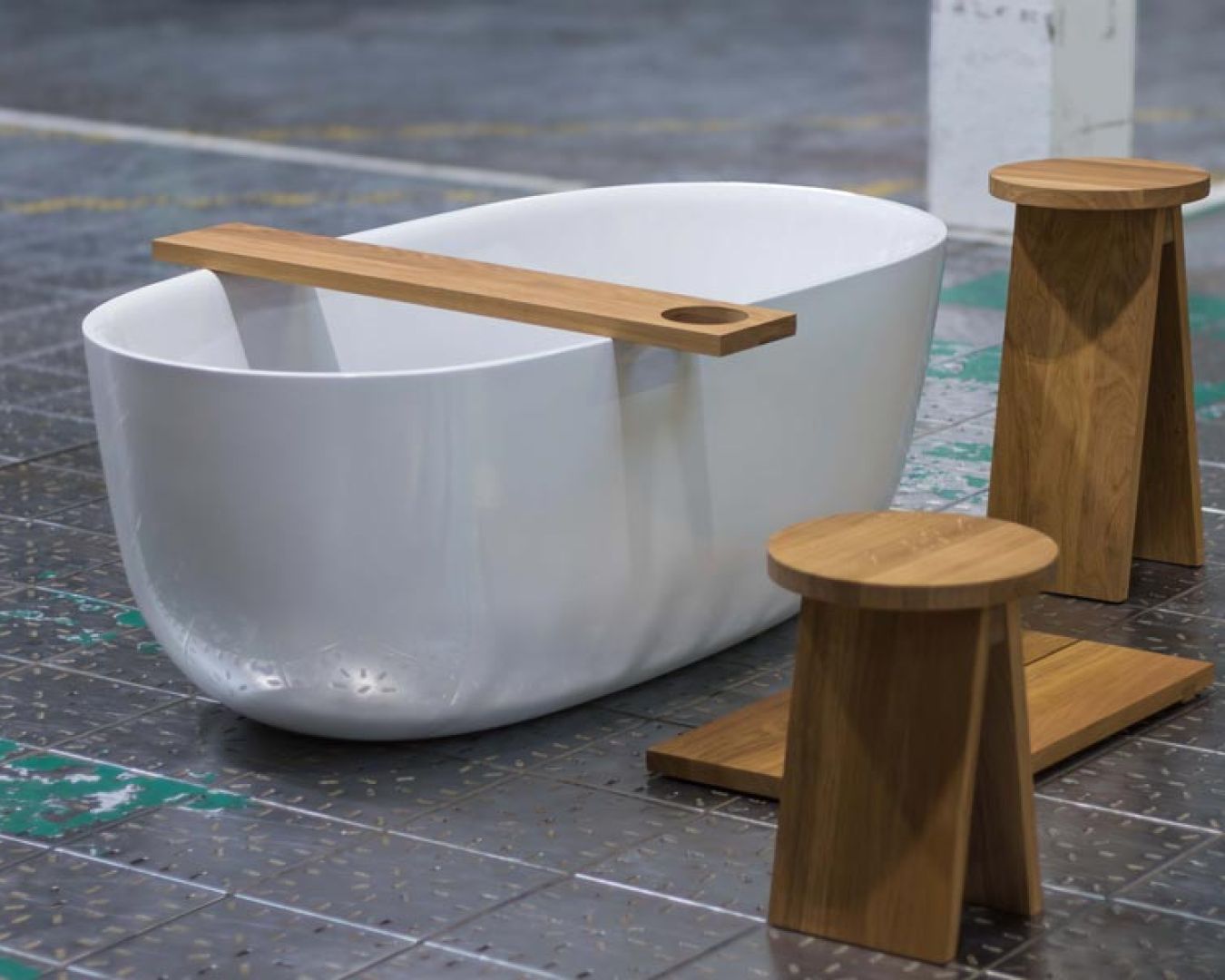 Freistehende Badewanne mit Holzauflage und Hocker auf Industriefliesen
