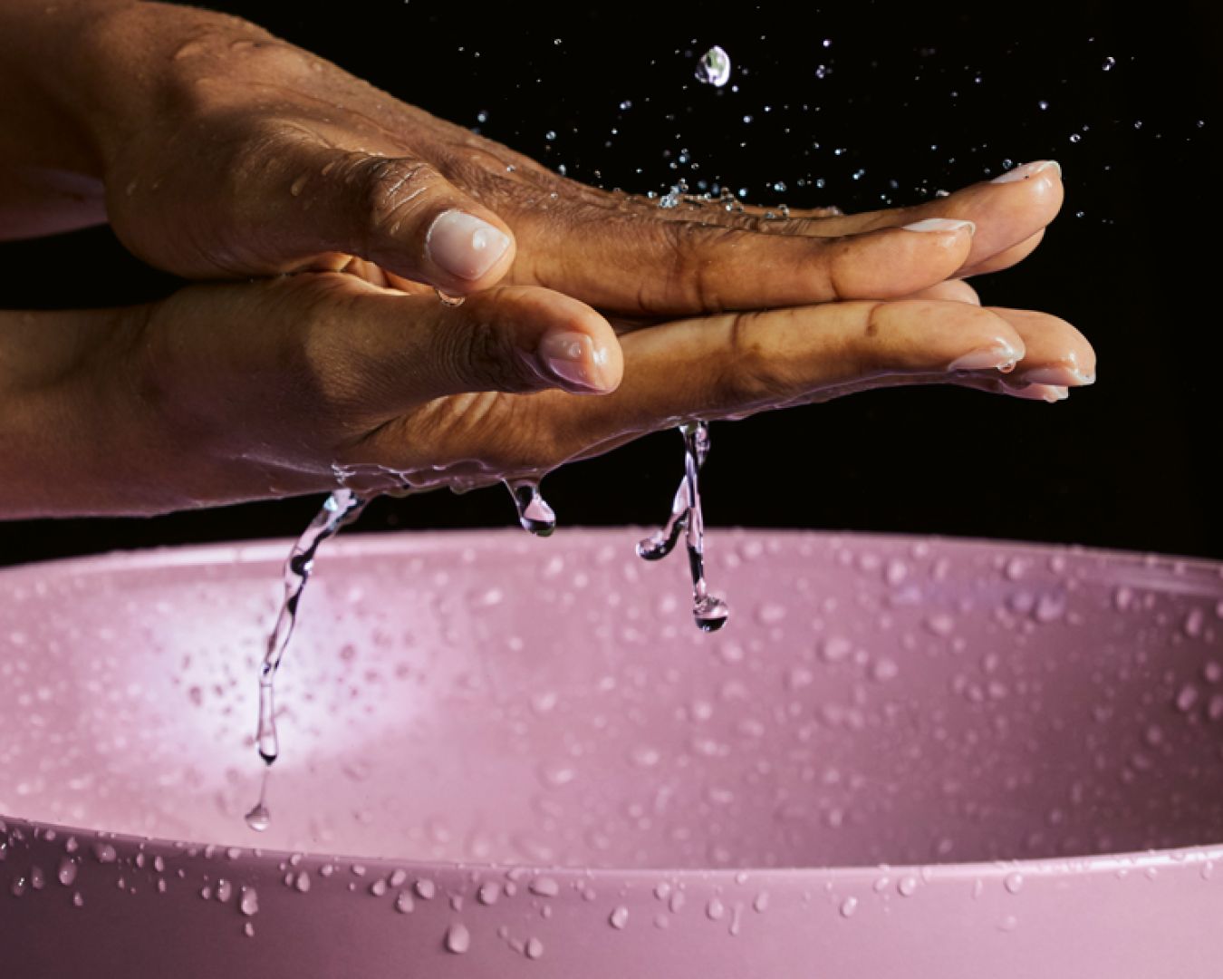 Händewaschen über einem Pinken Waschbecken
