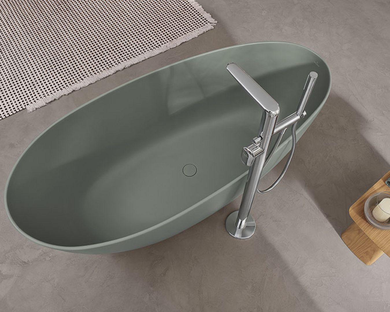 Freistehende, ovale Badewanne in Mattgrün mit moderner Standarmatur.