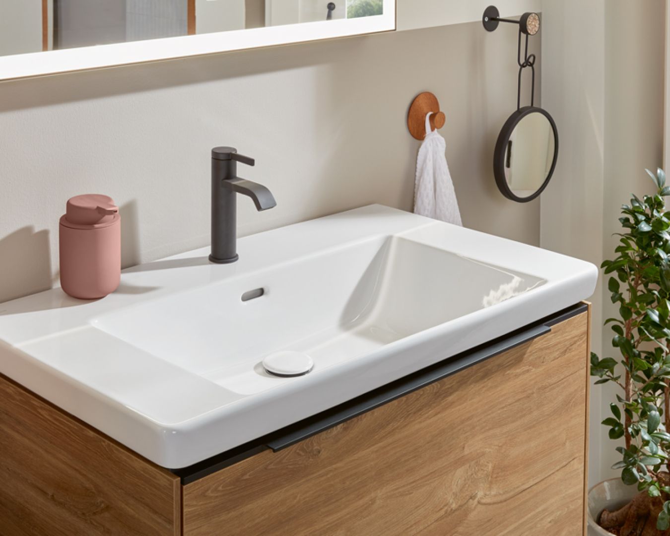 Modernes Waschbecken mit schwarzer Armatur und Holzunterschrank