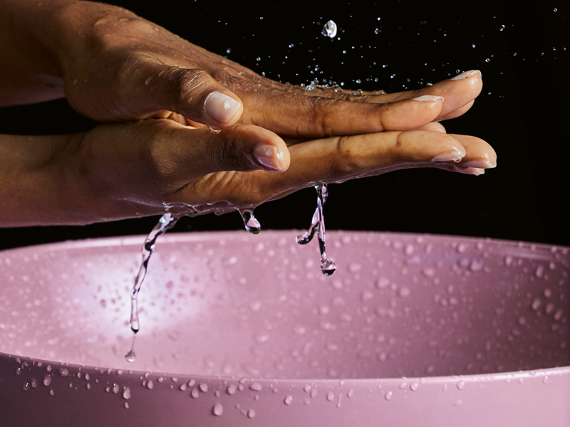 Händewaschen über einem Pinken Waschbecken