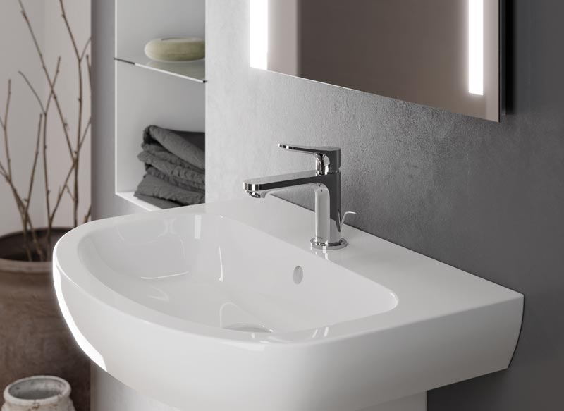 Modernes Waschbecken mit breitem Rand und glänzender Armatur an grauer Wand.