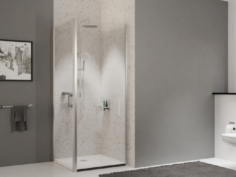 Eckdusche mit Glaswand und moderner Armatur vor grauer Fliesenwand


