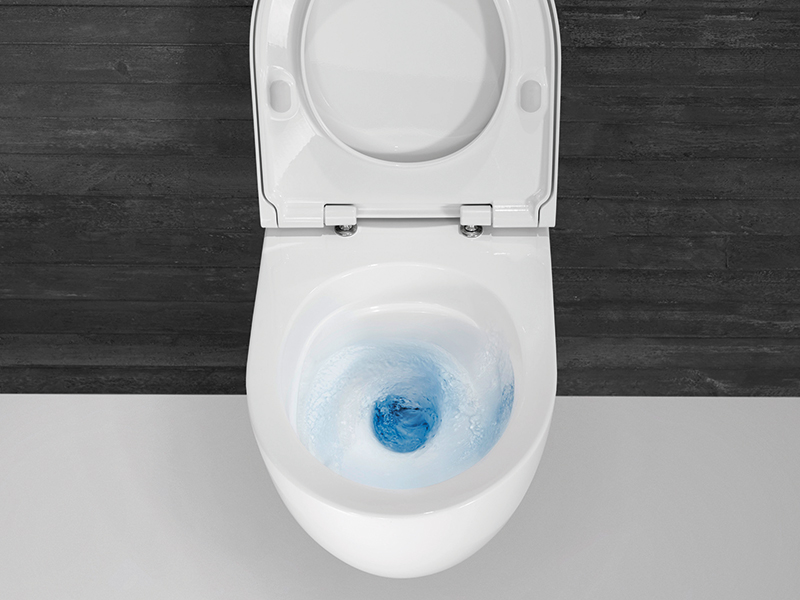 Spülvorgang in moderner wandhängender Toilette mit blauem Wasserwirbel