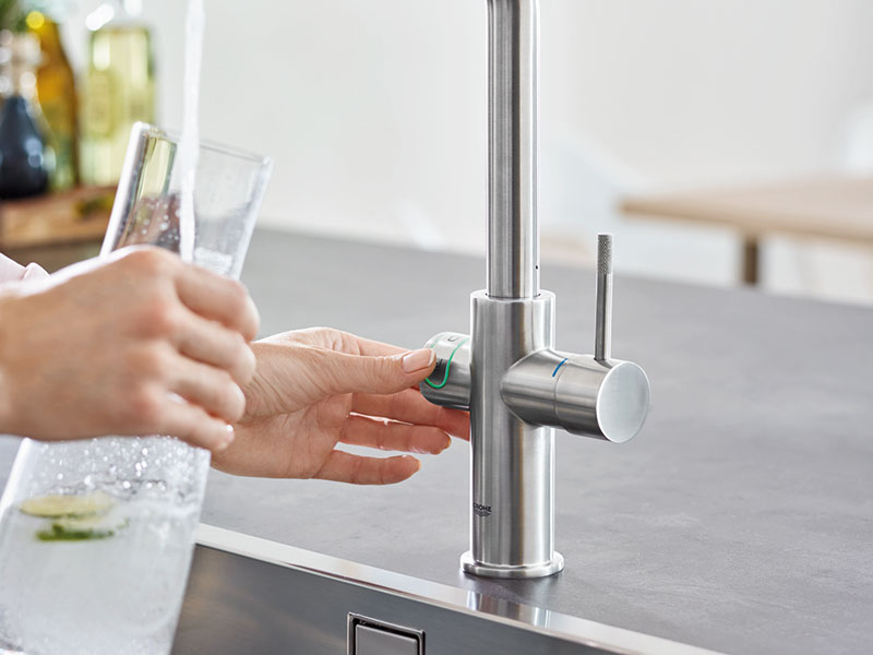 Moderne Küchenarmatur aus Edelstahl mit Glas und fließendem Wasser