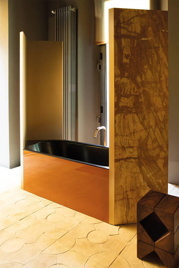 Luxuriöses Bad mit schwarzer Wanne, goldener Verkleidung und Marmorwand.