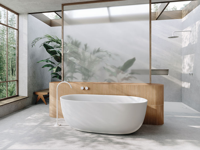 Offenes Bad mit freistehender Wanne, viel Licht und Naturblick.