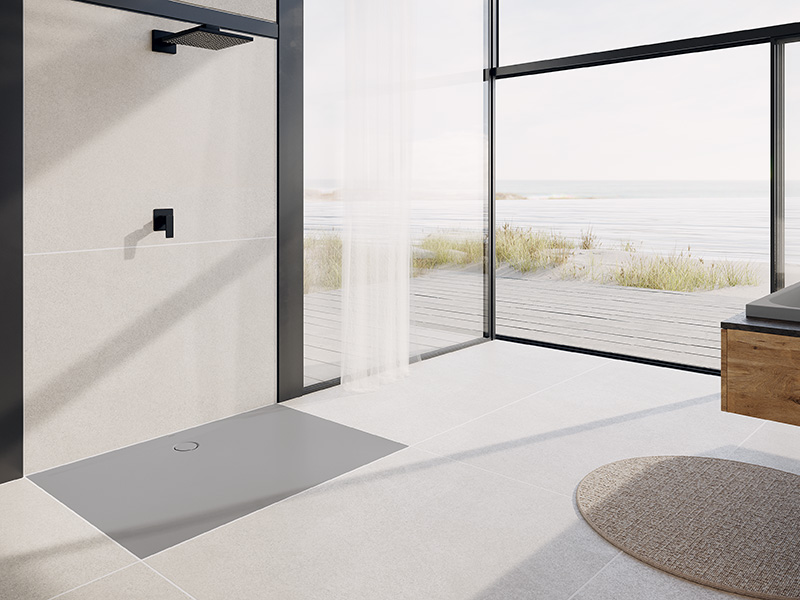 Ebenerdige Dusche mit grauer Fläche und Ausblick auf Dünen und Holzdeck.