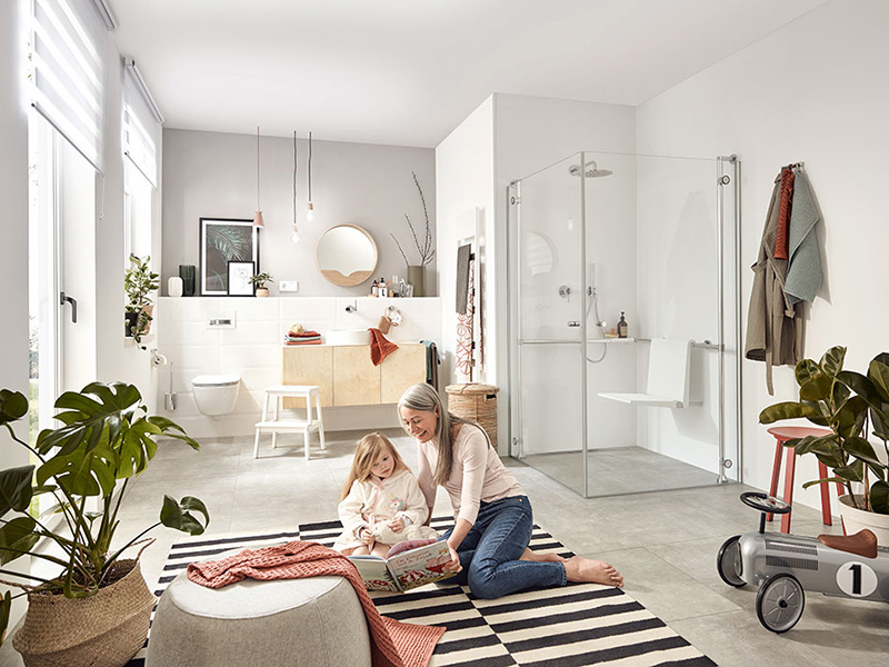 Familienfreundliches Bad mit barrierefreier Dusche und spielendem Kind auf Teppich.