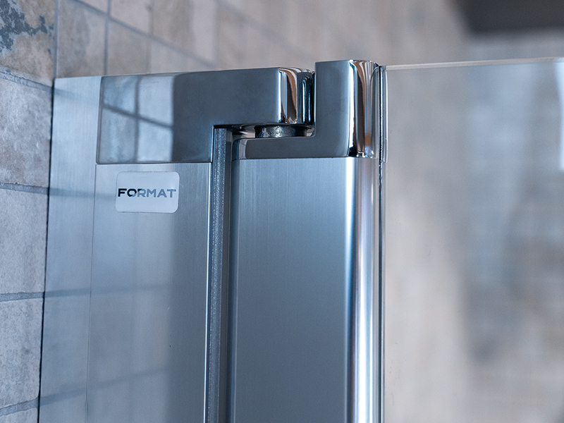 Format-Duschscharniere aus Metall an einer Glastür, montiert an Fliesenwand.