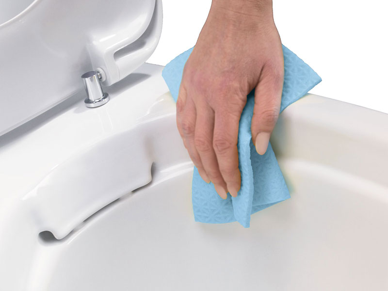 WC-Rand wird mit einem blauen Reinigungstuch von Hand gesäubert


