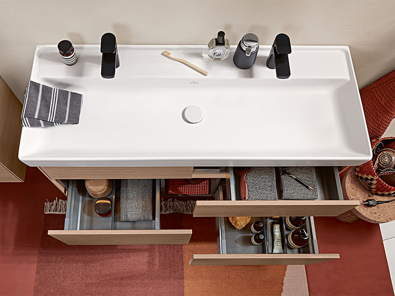 Modernes Waschbecken mit Stauraum und geöffneter Schublade von oben.