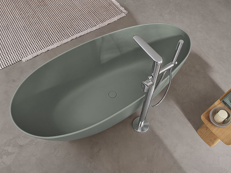Freistehende, ovale Badewanne in Mattgrün mit moderner Standarmatur.