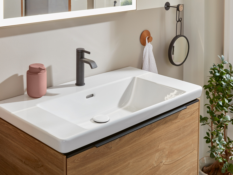 Modernes Waschbecken mit schwarzer Armatur und Holzunterschrank