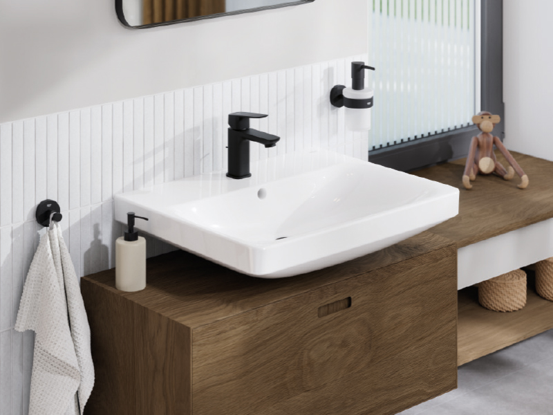 Waschbecken mit schwarzer Armatur und Holzunterschrank