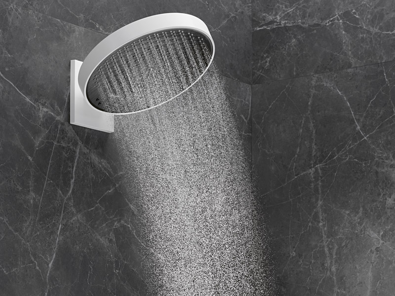 Große runde Regendusche mit feinem Wasserstrahl vor dunkler Steinwand