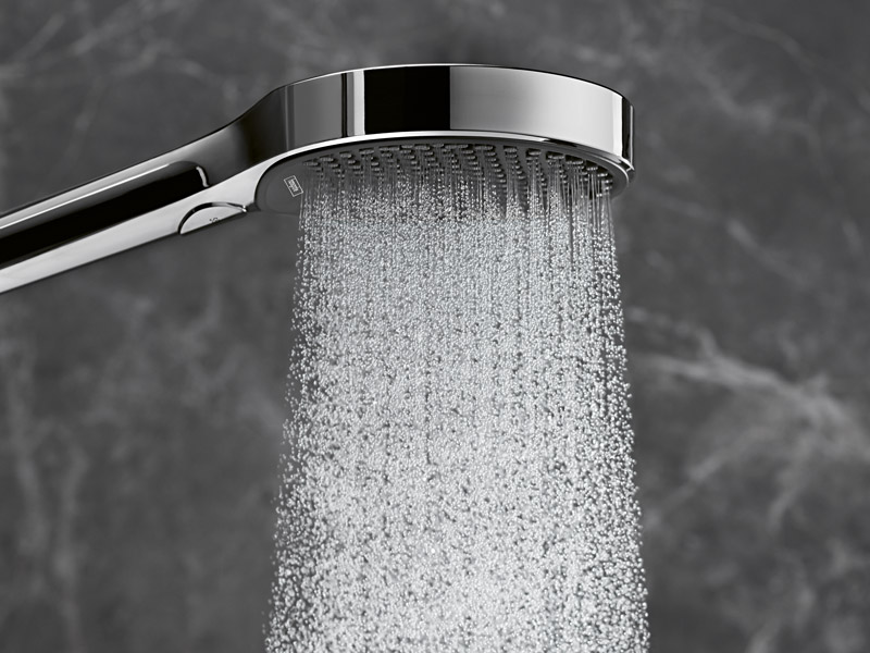 Handbrause mit gleichmäßigem Wasserstrahl vor grauer Marmorwand