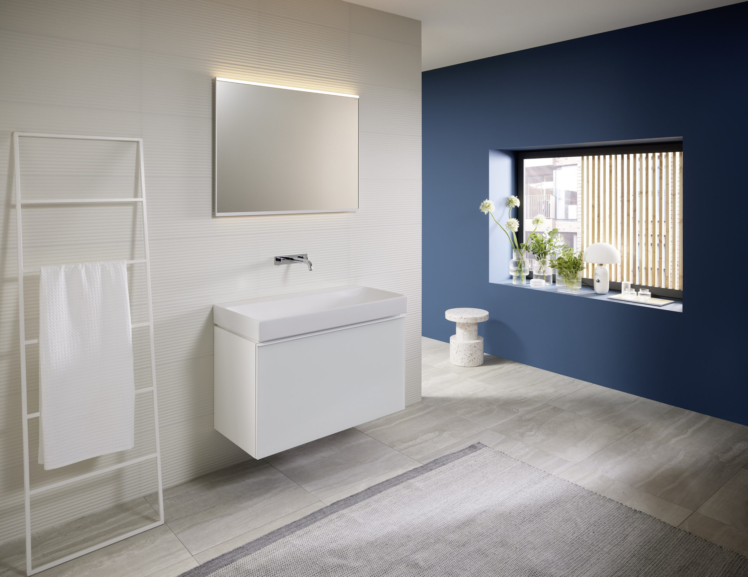 Modernes Bad mit Spiegelschrank und blauer Akzentwand mit Fenster